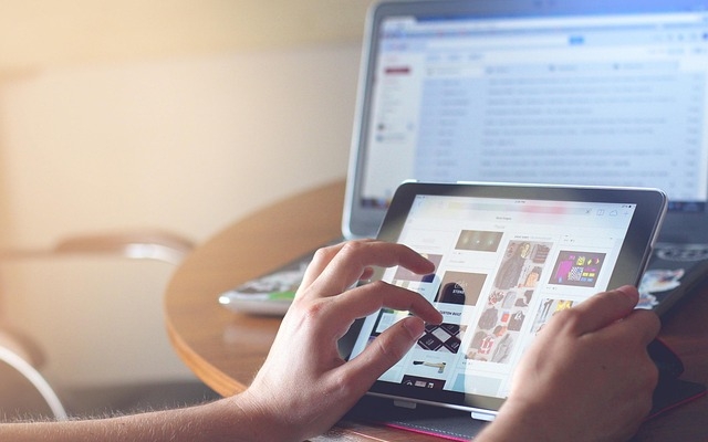 Afbeelding met een beeldscherm en handen die op het scherm scrollen